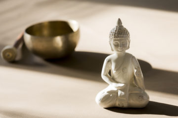 Yoga. Eine Klangschale und eine Buddah Statue